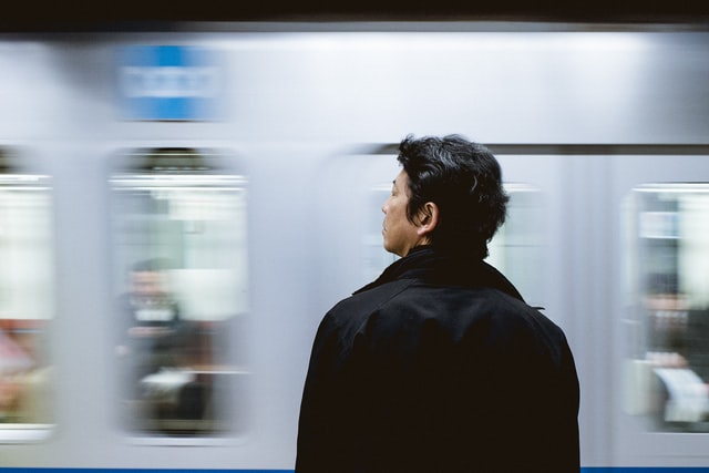 man looking at train passing by