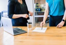 two people in an office looking over a document