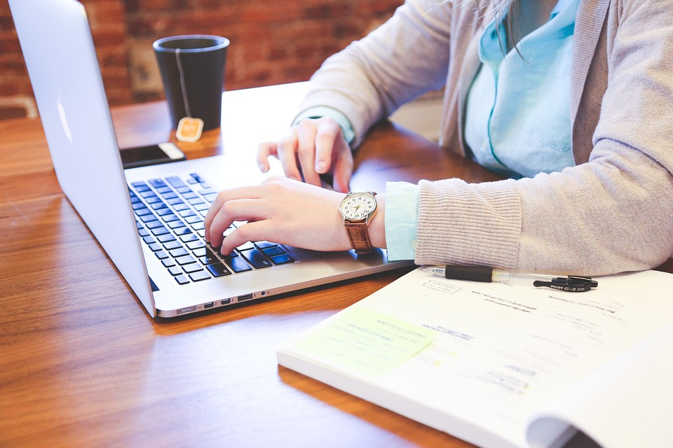 person in an office typing on a laptop